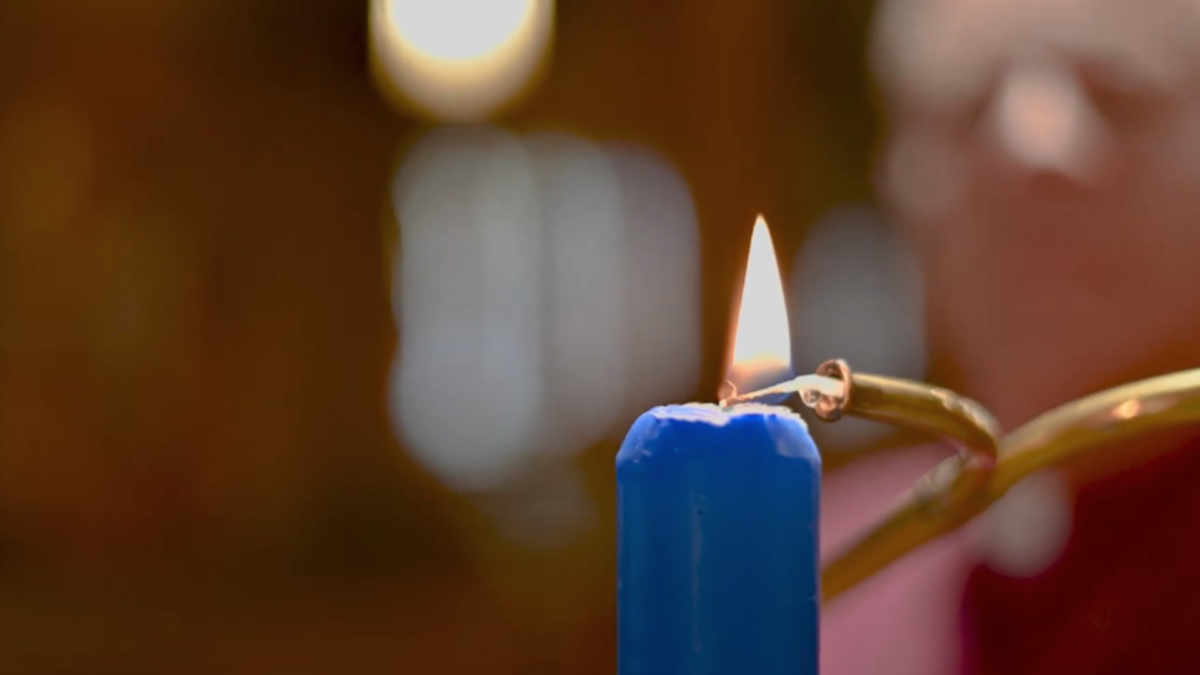 One blue candle being lit